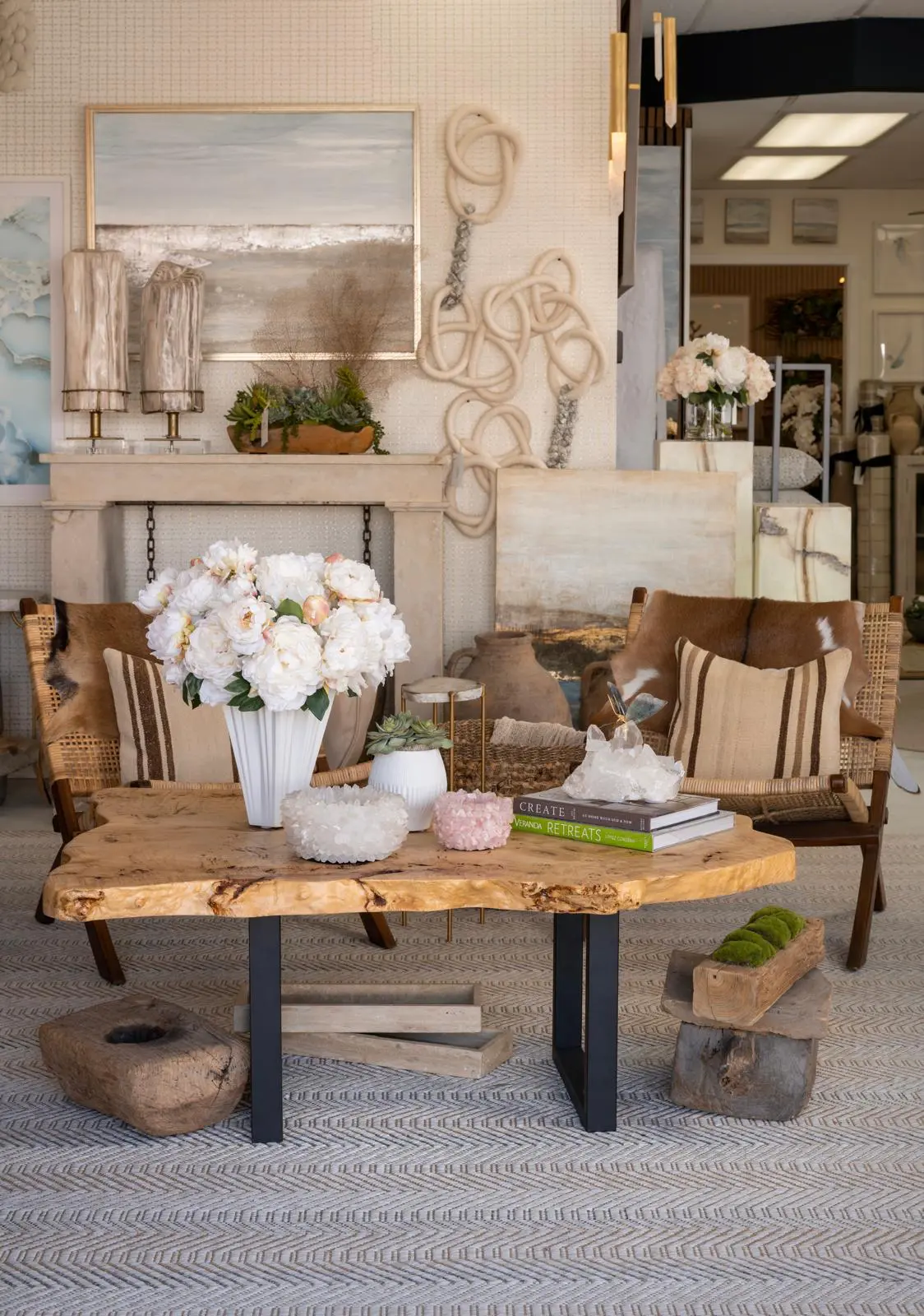 Haus of Aurah showroom with a live-edge wood coffee table, white peonies and curated decorative objects